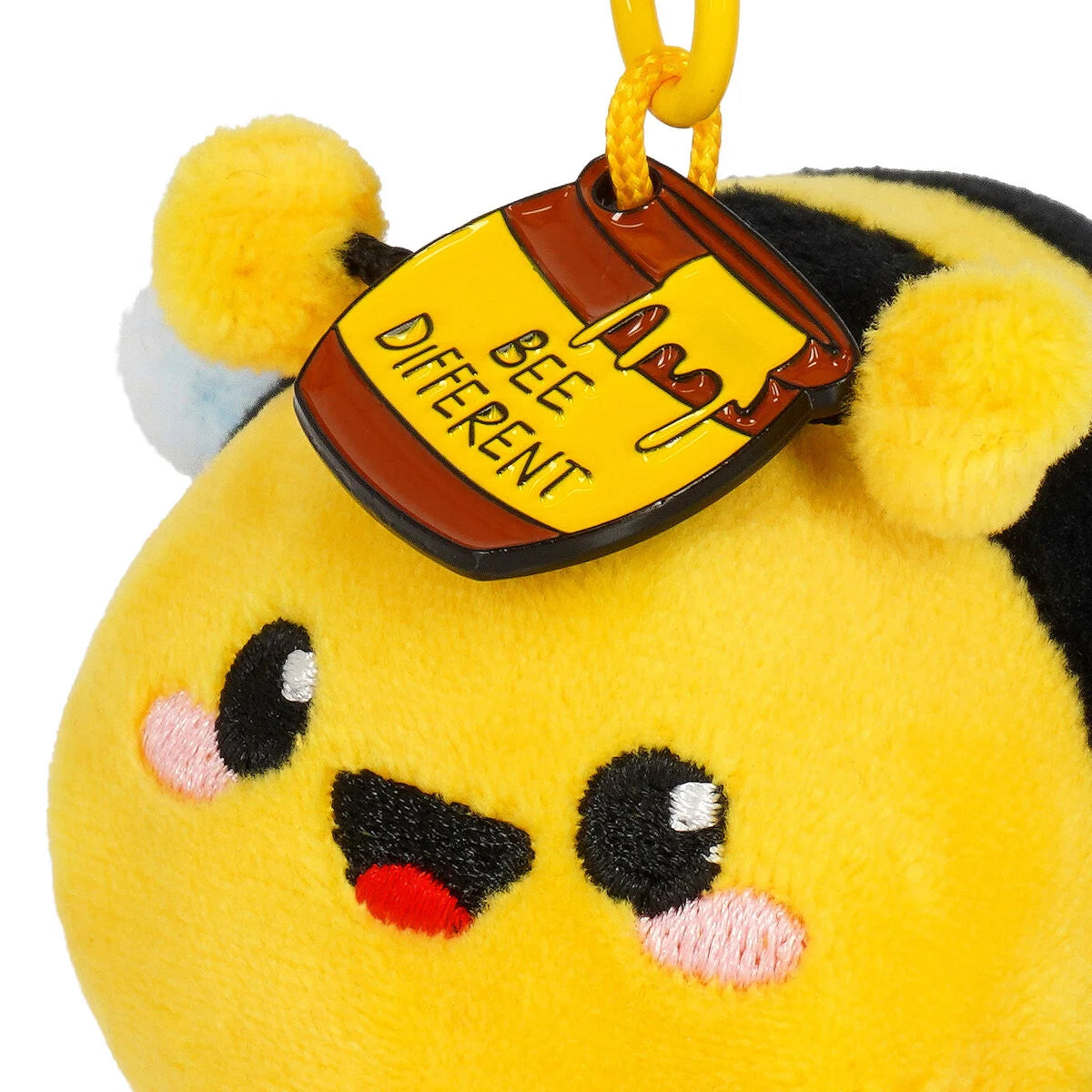 Plush bee keychain with a sign saying 'Bee Different' on a white background