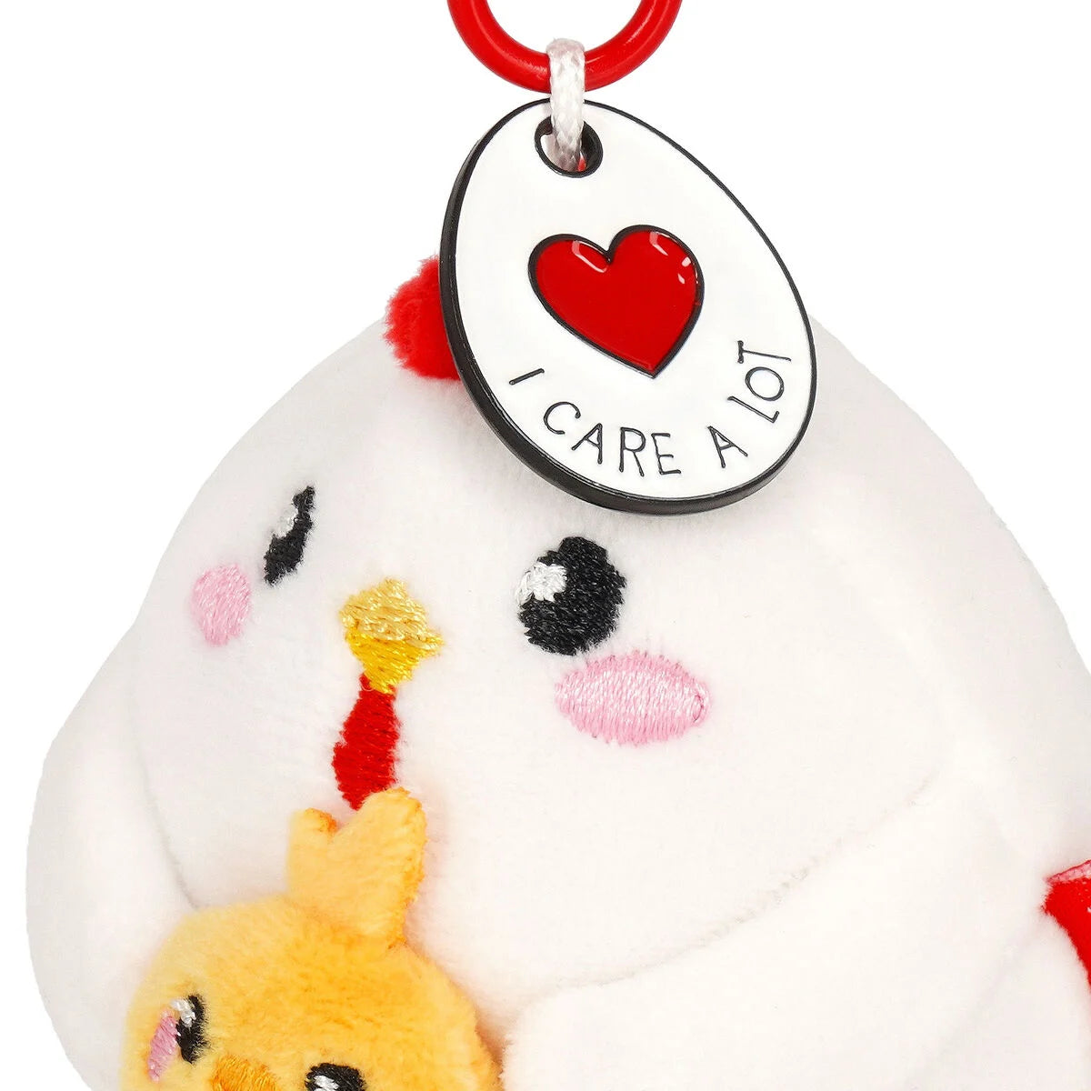 Plush keychain with a heart-shaped tag saying 'I Care A Lot' on a white background